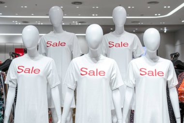 Alışveriş, iş modası ve reklam, siyah cuma ve noel konsepti için alışveriş mağazasında satılık beyaz giysiler içinde kadın mankenlerin bir kısmı.