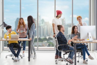 Asyalı ve çok ırklı iş adamlarından oluşan bir portre grubu modern iş yerinde, iş dünyası kavramında teknoloji bilgisayarı üzerinde kafa yoruyor ve birlikte çalışıyorlar.