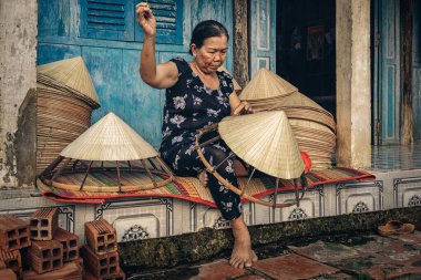 Vietnamlı yaşlı kadın zanaatkar geleneksel Vietnam şapkasını Ap Thoi Phuoc köyündeki geleneksel evde yapıyor, Hochiminh şehri, Vietnam, geleneksel sanatçı konsepti