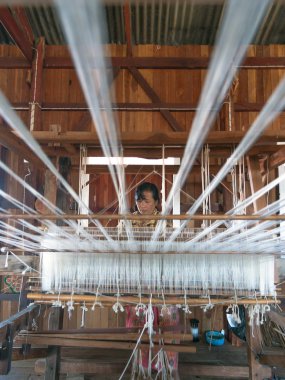 Inle, myanmar - Aralık 31: kimliği belirsiz bir kadın tarafından yöntemi ve makine üzerinde Aralık 31, 2010, geleneksel Inle, myanmar ipek kumaş dokuma. Inle Inle Gölü ziyaret etmek için turizm ünlü