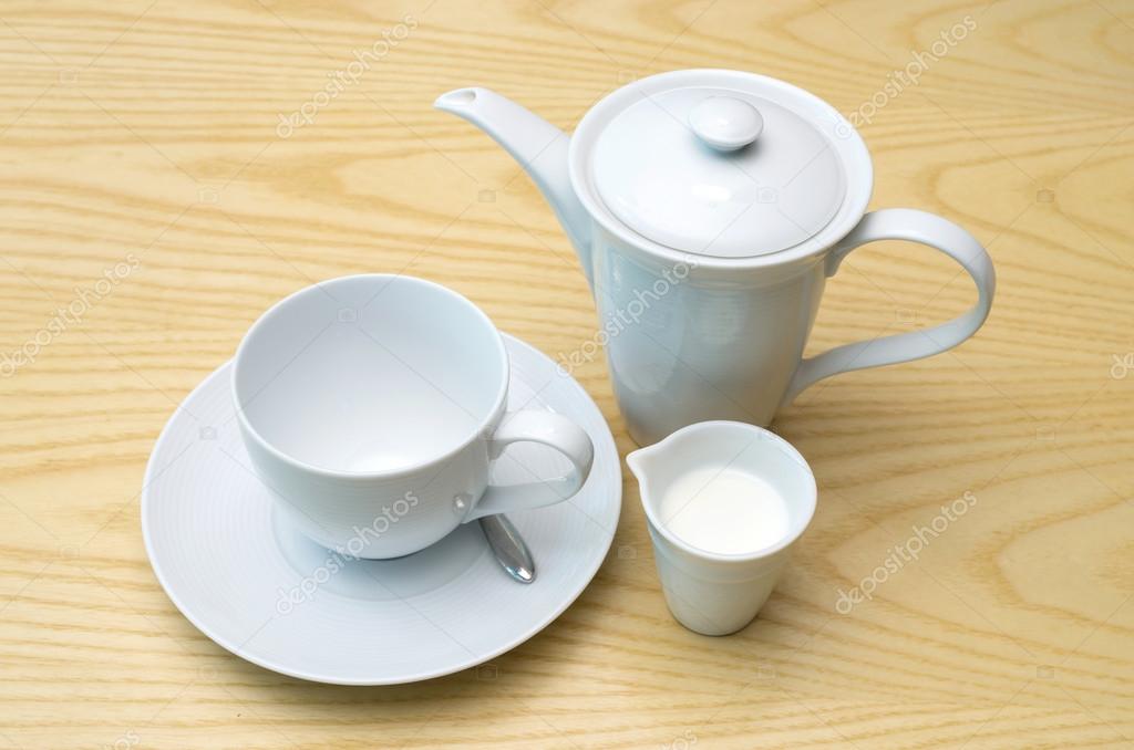 coffee in jug with white coffee cup and milk on the wood table