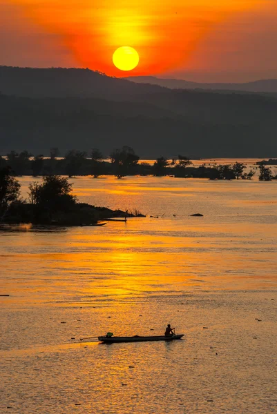 夕日、シルエットと釣り漁師パドリングの手漕ぎボート — ストック写真