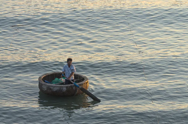 MUI NE, VIETNAM - 19 de setembro: Pescador indefinido que acolhe o barco tradicional na aldeia de Mui Ne, Vietnã, em 19 de setembro de 2012. Extração de frutos do mar é o principal negócio nas aldeias costeiras — Fotografia de Stock