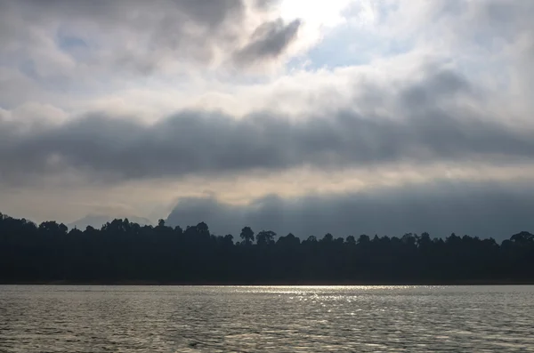 Rayos de sol que fluyen hacia el lago con fondo de montaña —  Fotos de Stock