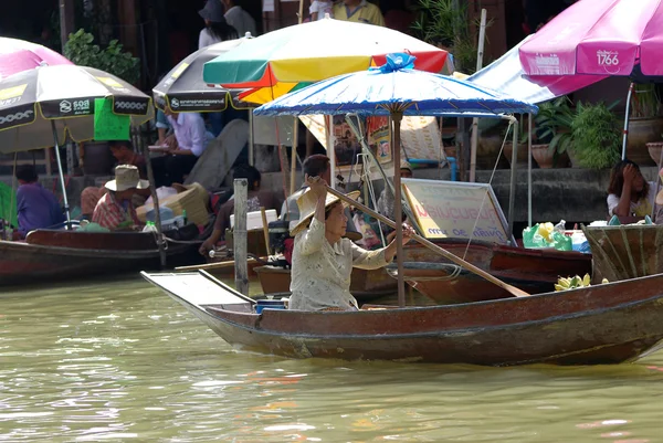 SAMUTSONGKHRAM - AGO 15: El viejo comerciante indefinido acolchando el barco tradicional de madera en el mercado flotante de amphawa, Samutsongkhram, Tailandia el 15 de agosto de 2009 . — Foto de Stock