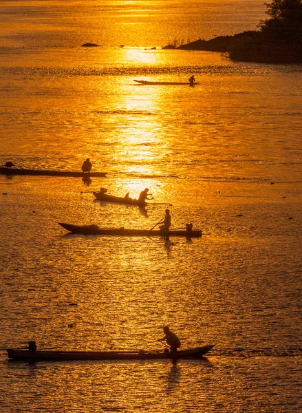Muitos pescador remando barco a remos para a pesca quando pôr do sol, Silhouet — Fotografia de Stock