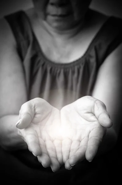 Light in old woman hands - praying — Stock Photo, Image
