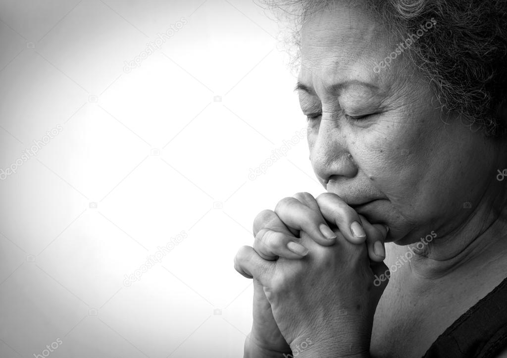 Old woman praying on white background