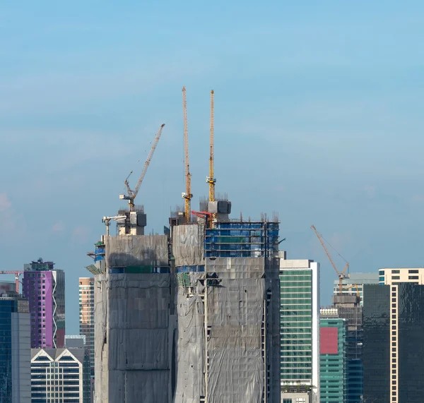 Kranen op een bouwplaats in midden van uitzicht op de moderne stad van b — Stockfoto