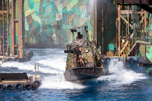 SINGAPORE - JULY 6: Undefined Stuntman in action shooting the machine gun on the warship in the live stunt show called Waterworld on July 6,2012 at the Universal Studios Singapore. — Stock Photo, Image