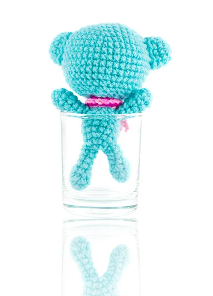 Handmade crochet blue bear doll in vodka glass on white backgrou — Stock Photo, Image