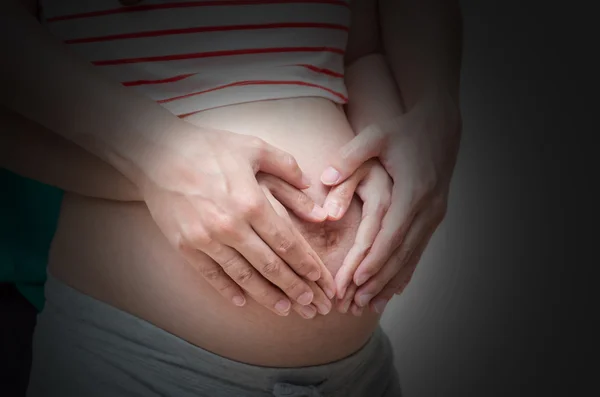 Loving couple hands on pregnant belly — Stock Photo, Image