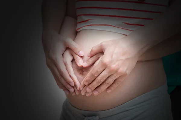 Loving couple hands on pregnant belly — Stock Photo, Image