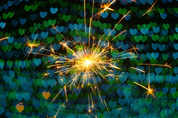 Electric sparklers with heart bokeh background — Stock Photo, Image