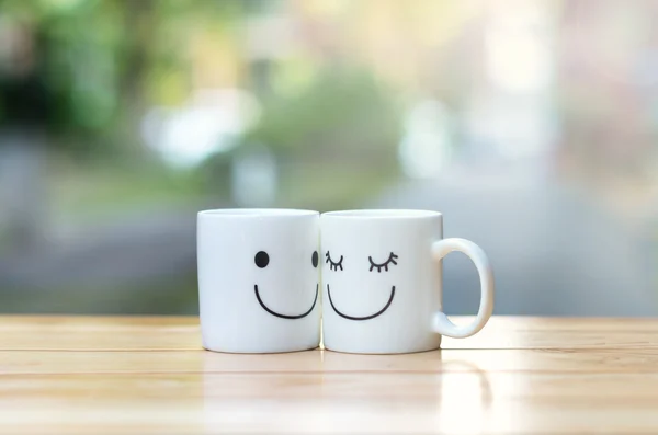 Dois copos felizes na mesa de madeira com bokeh, sobre o conceito de amor — Fotografia de Stock