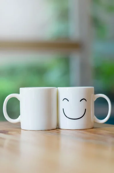 Zwei glückliche Tassen auf Holztisch mit Bokeh, über das Konzept der Liebe — Stockfoto