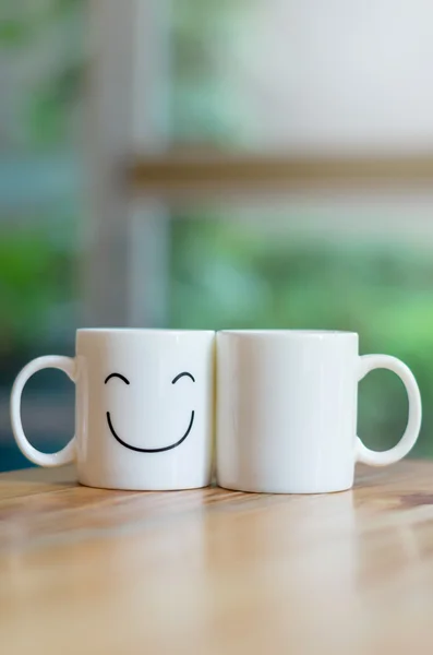 Dois copos felizes na mesa de madeira com bokeh, sobre o conceito de amor — Fotografia de Stock