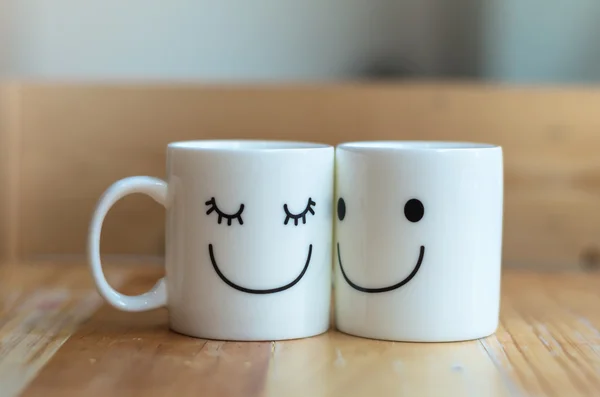 Two happy cups on wood table with bokeh, about love concept — Stock Photo, Image