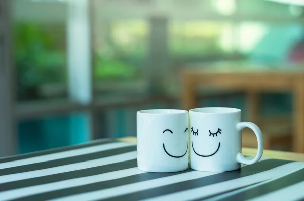 Zwei glückliche Tassen auf dem Tisch, über das Konzept der Liebe — Stockfoto