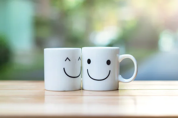 Dois copos felizes na mesa de madeira com bokeh, sobre o conceito de amor — Fotografia de Stock