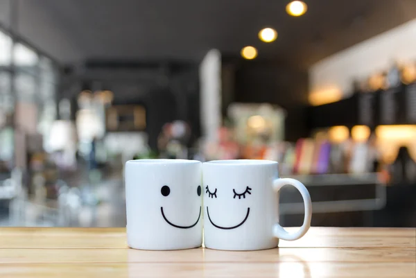 Two happy cups on coffee store blur background — Stock Photo, Image