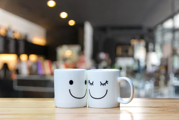 Twee gelukkige kopjes op koffie winkel wazig achtergrond — Stockfoto