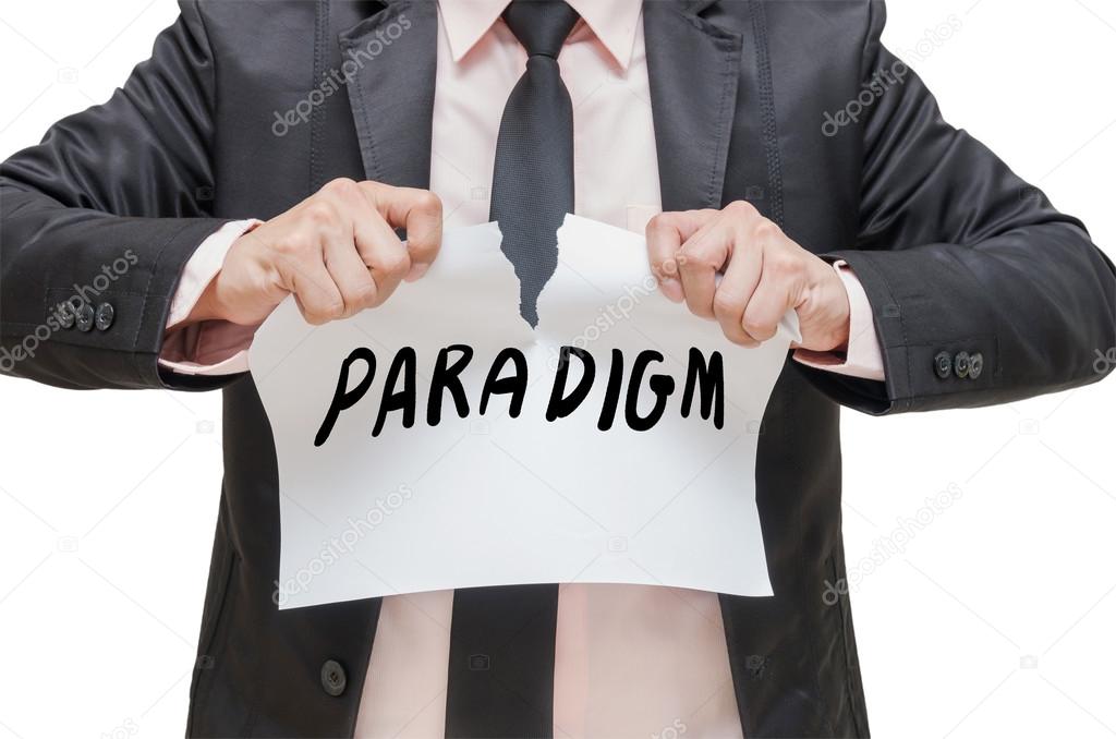 Businessman ripping up the PARADIGM sign on white background