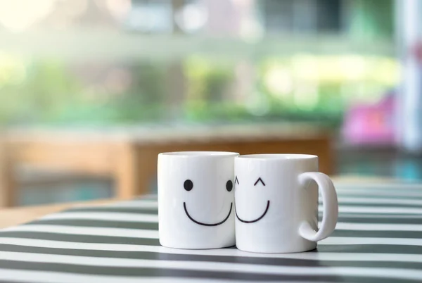 Zwei glückliche Tassen auf dem Tisch, über das Konzept der Liebe — Stockfoto