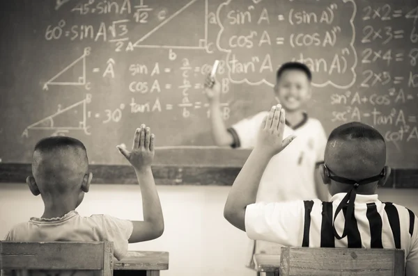 Dibesarkan tangan di kelas di sekolah negeri antara teman sekelas — Stok Foto