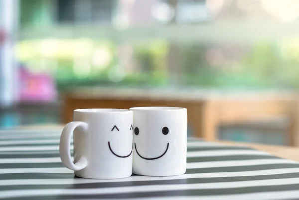 Duas xícaras felizes na mesa, sobre o conceito de amor — Fotografia de Stock