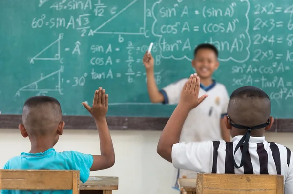 Levantar las manos en el aula en el campo Escuela entre compañeros de clase — Foto de Stock