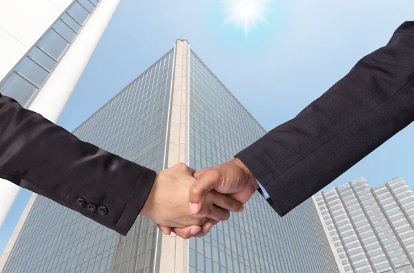 Hand shake between a businessman on Modern glass building backgr — Stock Photo, Image