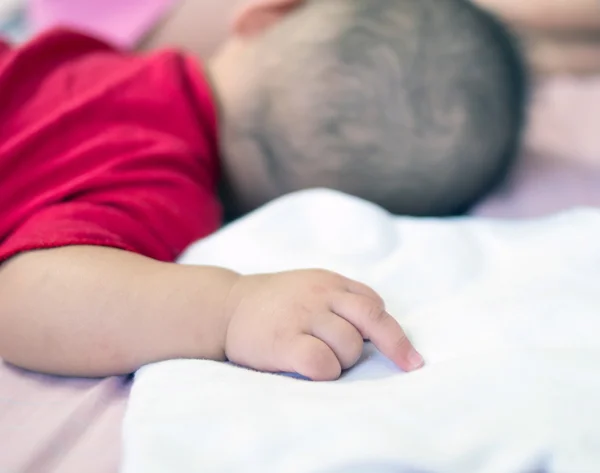 Azjatycki dziecko śpi na łóżku z środkowy palec — Zdjęcie stockowe
