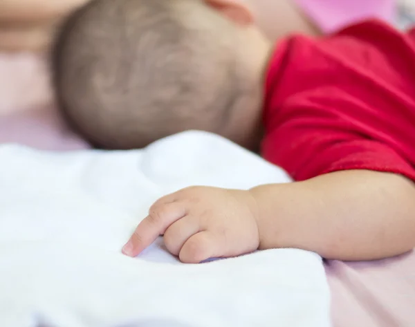 Aziatische baby slapen op het bed met middelvinger — Stockfoto
