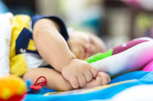 Baby hand op het bed — Stockfoto