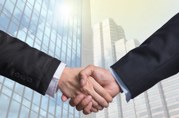 Hand shake between a businessman on Modern glass building backgr — Stock Photo, Image