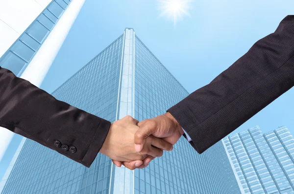 Agitar la mano entre un hombre de negocios en el edificio de vidrio moderno backgr —  Fotos de Stock