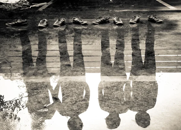 Четыре человека отражение в воде после дождя, двойное воздействие — стоковое фото