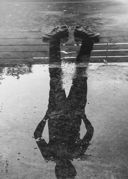 Мужское отражение в воде после дождя — стоковое фото