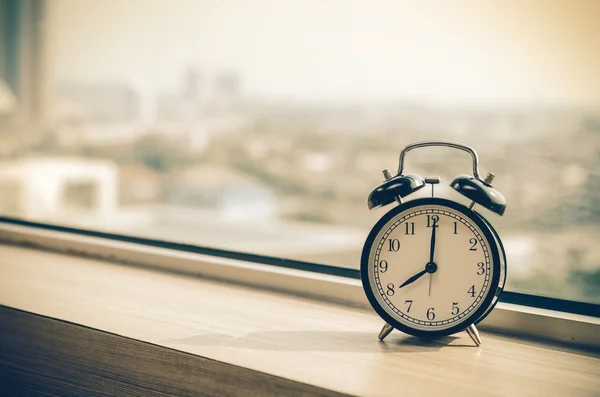 Reloj despertador vintage en ventanas a primera hora de la mañana — Foto de Stock