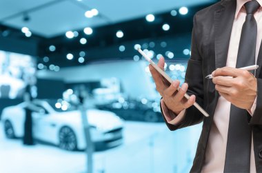 Bir işadamı ve bir iş kadını soyut bulanık fotoğraf Otomobil Fuarı arka plan arasında el sallamak