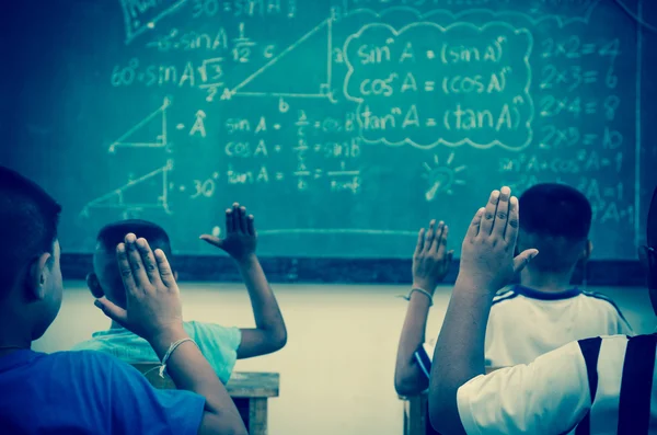 Levantar las manos en el aula en el campo Escuela entre compañeros de clase — Foto de Stock