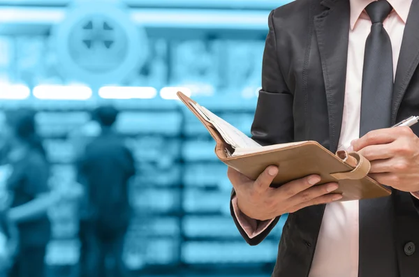 Businessman using the tablet on abstract blurred photo of motor show background — Stock Photo, Image