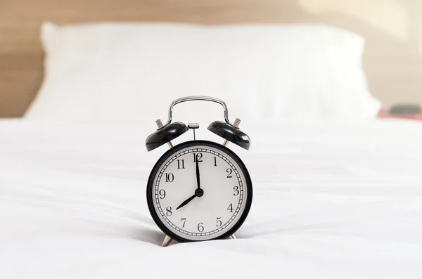 Reloj despertador vintage en la cama —  Fotos de Stock