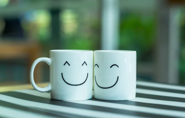 Дві щасливі чашки на столі, про концепцію кохання — стокове фото