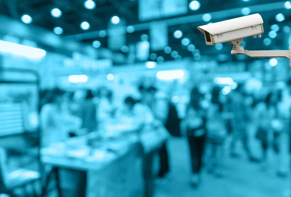 Cámara de seguridad CCTV en el monitor del centro comercial con la gente en fondo de foto borrosa abstracta, tono de color azul —  Fotos de Stock