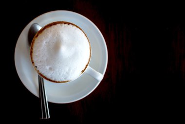 Koyu ahşap masa, üstten görünüm üzerinde sıcak Cappuccino