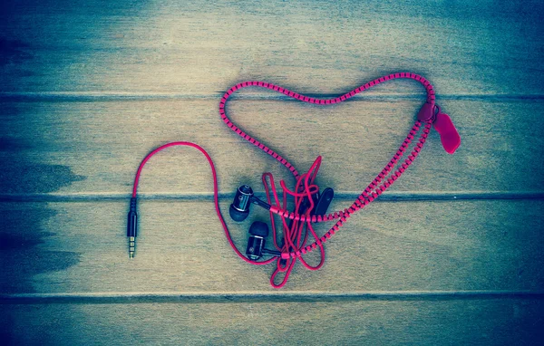 Auriculares de audio portátiles con corazón Crochet sobre fondo de madera, tono de color vintage — Foto de Stock