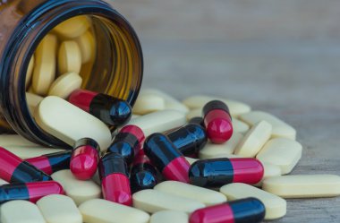 Birçok hap ve vitamin ahşap zemin üzerine tıp şişelerde