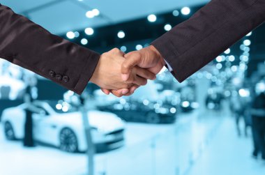 Bir işadamı ve bir iş kadını Otomobil Fuarı arka plan, mavi renk tonu soyut bulanık fotoğraf arasında el sallamak